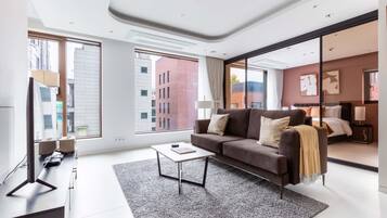 A modern living room with a sofa, coffee table, and a large window.