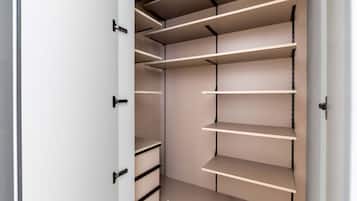 A walk-in closet with multiple shelves and drawers.
