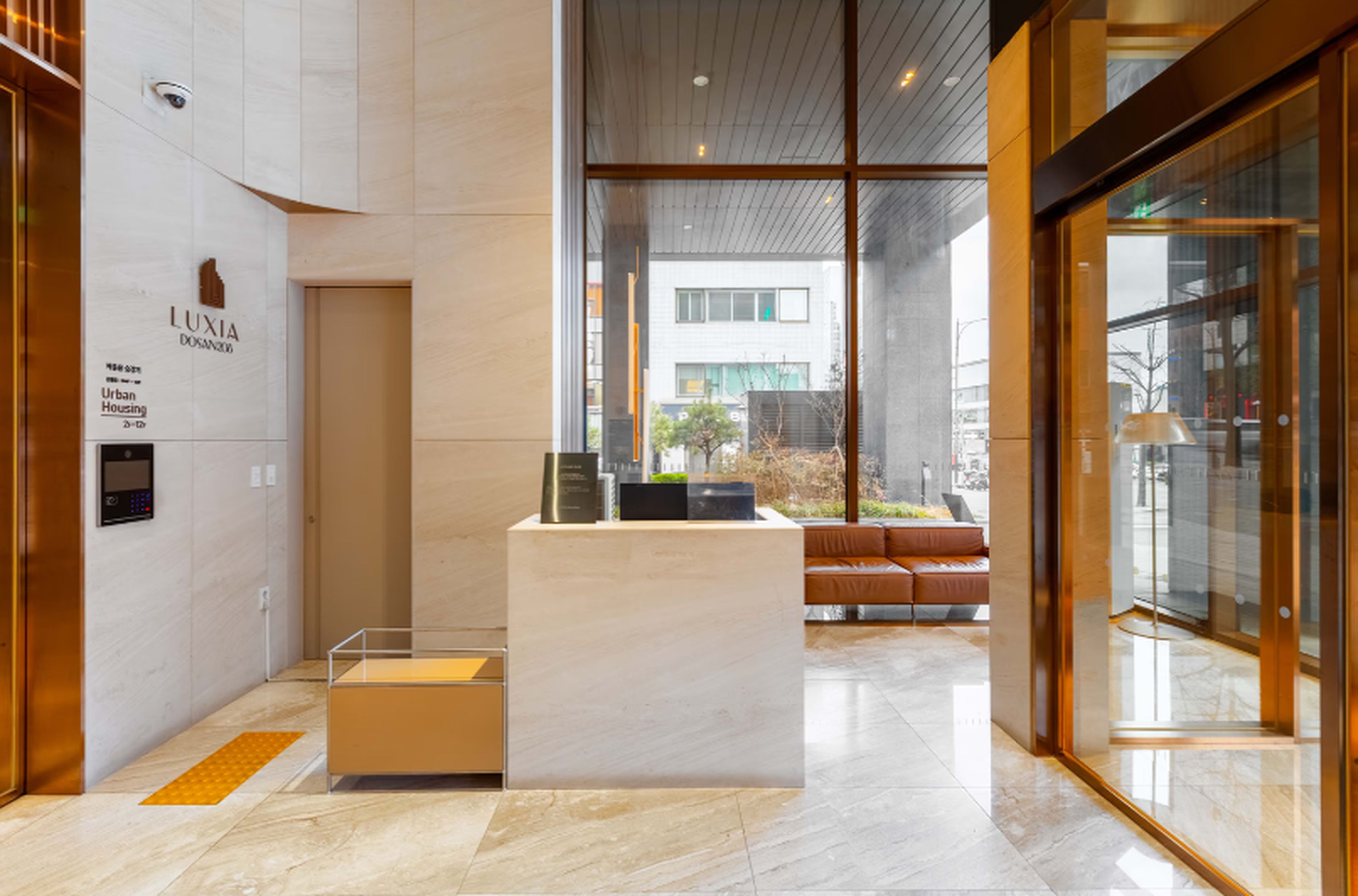 A modern reception area with a marble floor, a reception desk, and a seating area with a sofa.