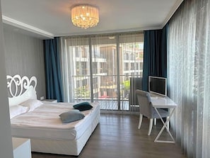 A hotel room with a bed, a desk, and a television. - Regina Maria Spa Design Hotel (Balchik)