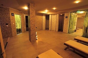 A room with tiled walls, benches, and a door leading to a bathroom. - Regina Maria Spa Design Hotel (Balchik)