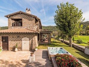A stone house with a patio, a hot tub, and a garden. - Podere La Cavallara by Interhome (Lago di Bolsena)