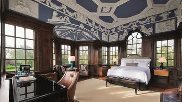 A spacious bedroom with a large bed, a desk, and a chair.