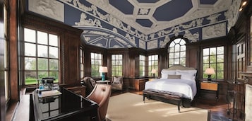 A spacious bedroom with a large bed, a desk, and a chair.