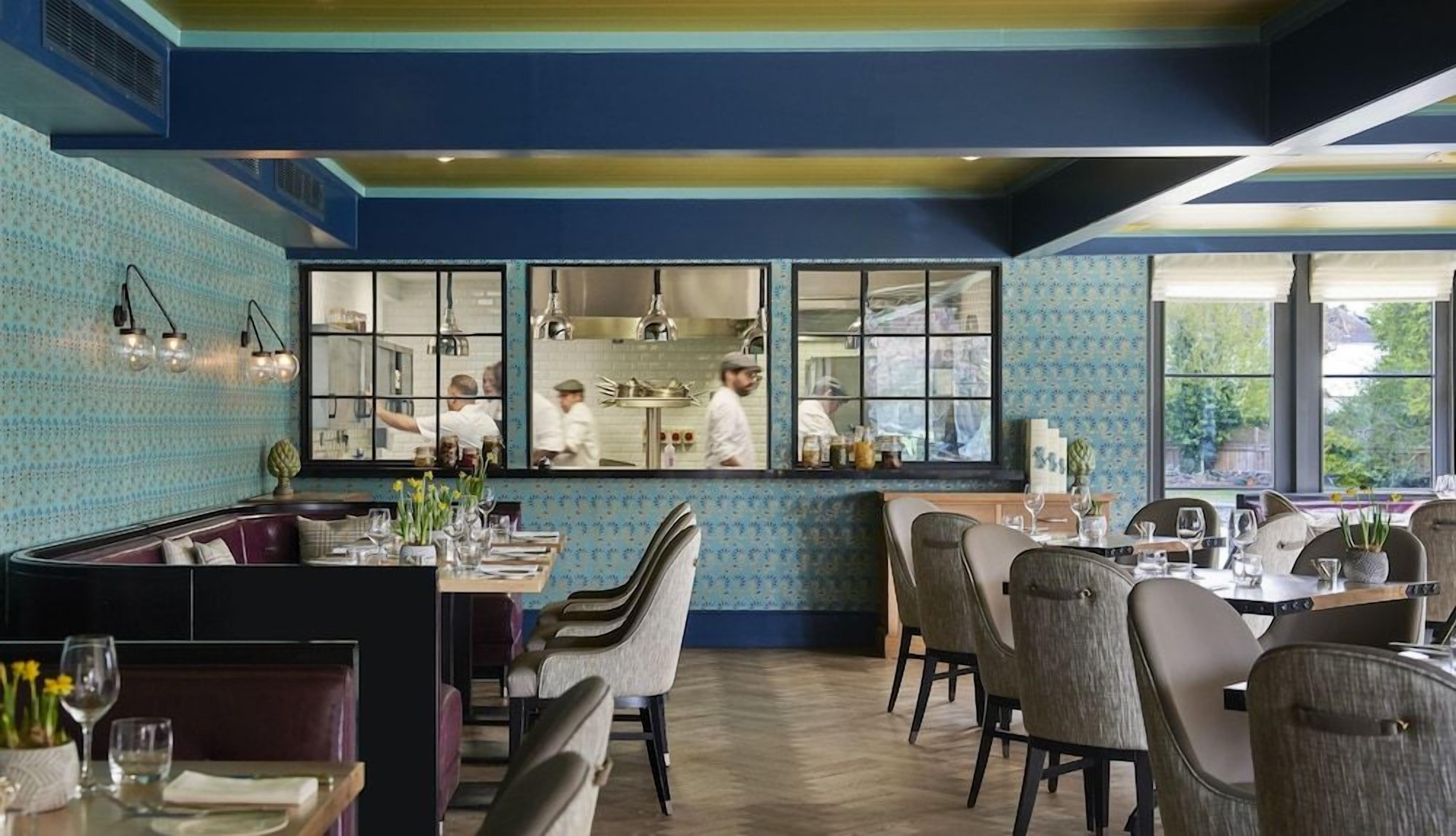 A restaurant with a bar area, dining tables, and chairs.