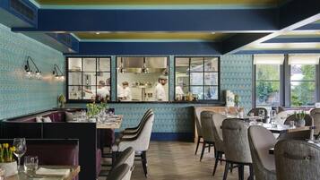 A restaurant with a bar area, dining tables, and chairs.