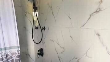 A bathroom with a shower, a toilet, and a sink.