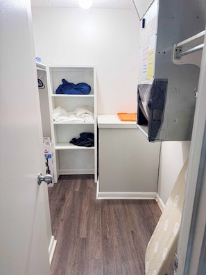A compact room with a wardrobe, a small desk, and a bed.