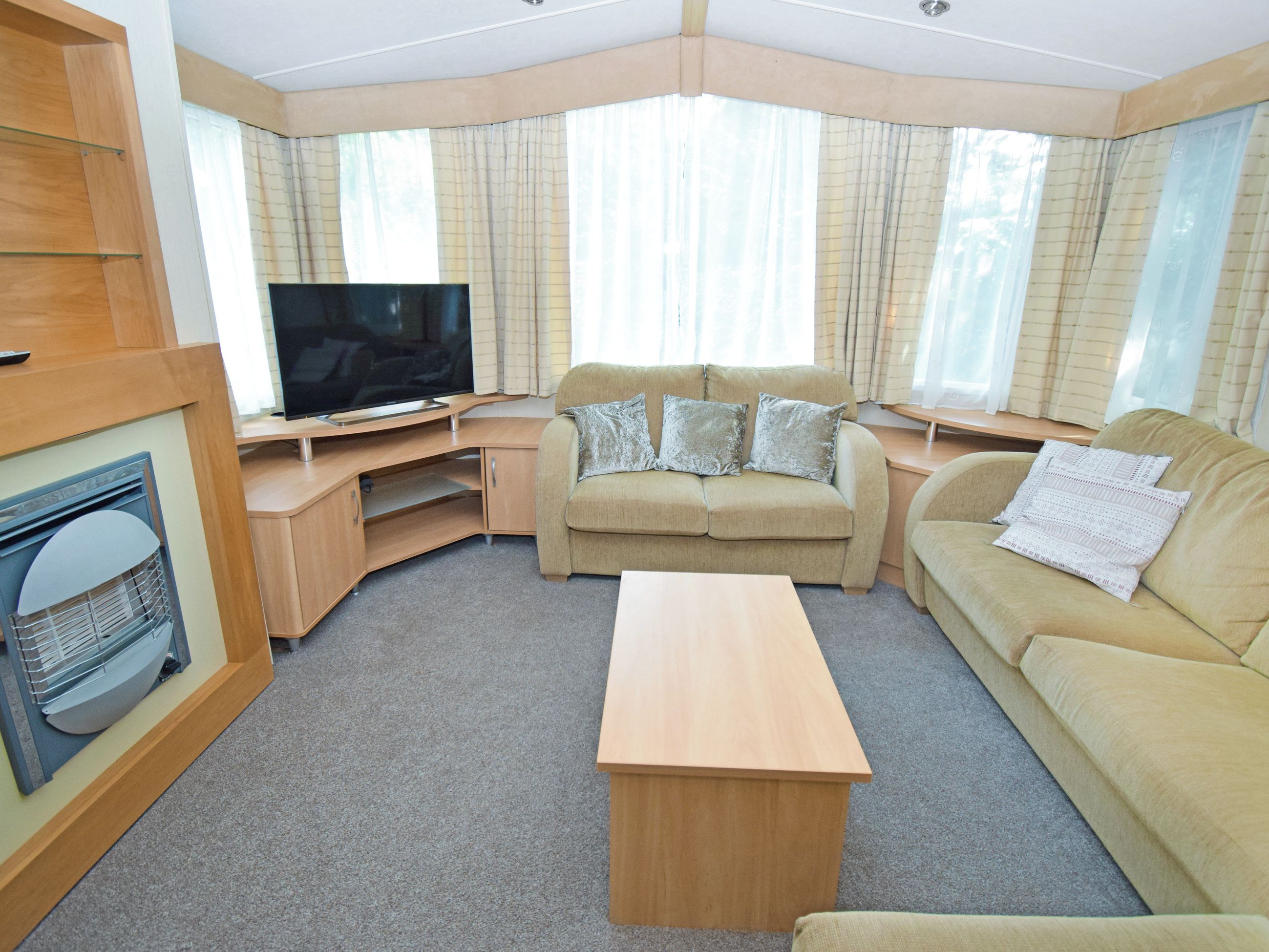 A compact living space with a sofa, a television, and a small table.