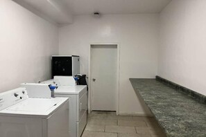Une buanderie équipée d’un lave-linge, d’un sèche-linge et d’un petit réfrigérateur.