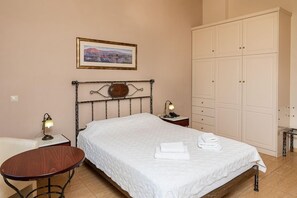 Una camera da letto con un letto, comodini, un armadio e un quadro appeso al muro.
