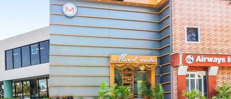 A hotel with a modern facade, a Marotel metro sign, and an Airways Inn sign.