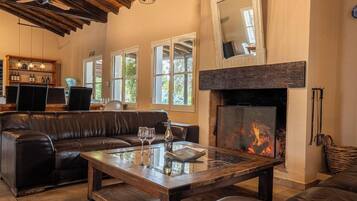Una sala de estar acogedora con chimenea, muebles de cuero y una estantería.
