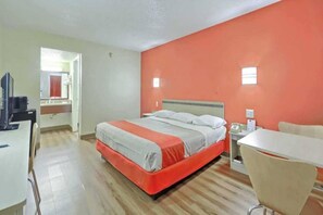 A hotel room with a bed, a desk, a chair, and a television. - 1 King Bed | Smoking (Maple Shade)