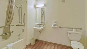 Een badkamer met een bad, wastafel, toilet en spiegel.