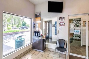 A poolside area with a view of the street, a counter with a chair, and a sign indicating no food or drinks inside the pool area.