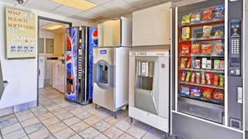 A commercial space with vending machines, a refrigerator, and a sign for soap and bleach.