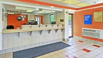 A reception area with a counter, a computer, and a wall-mounted sign.