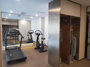 Ein moderner Fitnessbereich mit Laufbändern, Ergometer und einer Spiegelwand.