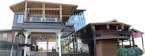 Un edificio de varios pisos con una fachada de vidrio destacada y una estructura de madera tradicional con balcón.