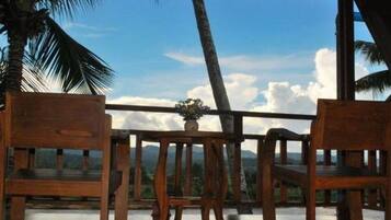 A wooden deck with a view of mountains and a clear sky.