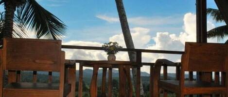 Una terraza de madera con vistas a montañas y cielo despejado.