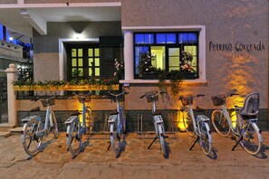 Een hotelentree met een rij fietsen die er buiten staan.