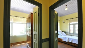 A hallway leading to a bedroom with a bed, a window, and a door. - Petrino Gokceada Hotel (Gökçeada)
