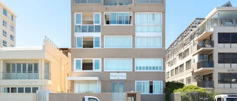 A multi-story hotel with a flat facade, large windows, and a gated entrance.