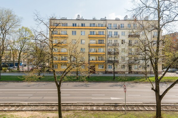 A multi-story residential building with balconies and a clear view of the street in front. - P&O Waszyngtona (Warsaw)