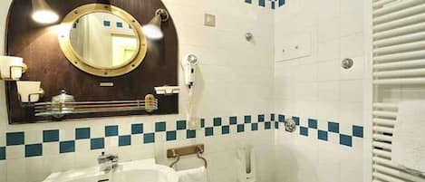 A bathroom with a round mirror, a sink, and a toilet.