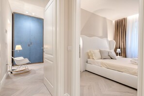 A hotel room with a bed, a chair, a desk, and a wardrobe. - Luxury Blue River (Florence)