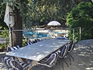 An outdoor dining area with a pool in the background. - Breathtaking house in Crafers West - sleeps 10 (Crafers West)