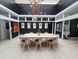 A dining area with a central table surrounded by chairs, a chandelier, and artwork on the walls. - Breathtaking house in Crafers West - sleeps 10 (Crafers West)