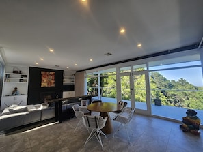 A modern living room with a dining area, large windows, and a view of the outdoors. - Breathtaking house in Crafers West - sleeps 10 (Crafers West)