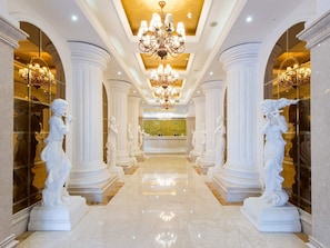 A grand hallway with white columns, a chandelier, and statues. - Viennahotel Banxuegang Road (Shenzhen)