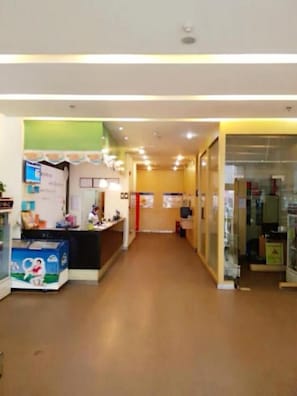 A hotel corridor with a reception desk, a counter, and a glass display case. - 7 Days Inn Xian Northwest University North Gate Branch (Xi'an)