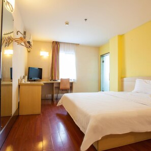 A hotel room with a bed, desk, chair, television, and a mirror. - 7 Days Inn Xian Northwest University North Gate Branch (Xi'an)