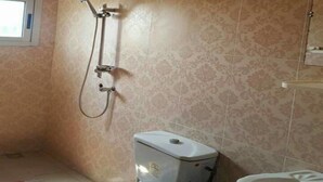 A bathroom with a toilet, bidet, and shower. - Les Residences Rima 9 (Abidjan)