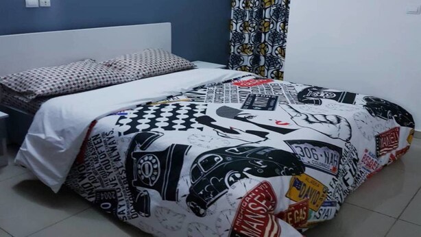 Ein Schlafzimmer mit einem Bett, einer Wand-Klimaanlage und einem gemusterten Vorhang.