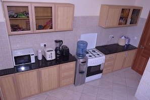 A kitchen with a stove, microwave, toaster, and cabinets. - Ringsview (Barsaloi)