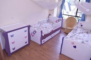A child's bedroom with a bed, a dresser, and a chair. - Ringsview (Barsaloi)