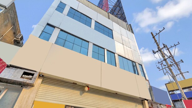 Un edificio de varios pisos con grandes ventanales y una entrada visible en la planta baja.