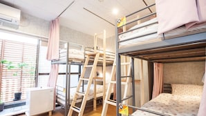 A dormitory room with bunk beds, a ladder, a desk, and a window with blinds. - Akasaka-no Sato Female Only (Tokyo)