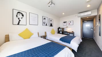 A hotel room with two beds, a desk, a chair, a lamp, and a door.