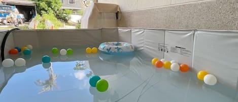 A pool with a clear water surface, surrounded by a white wall with a textured pattern.