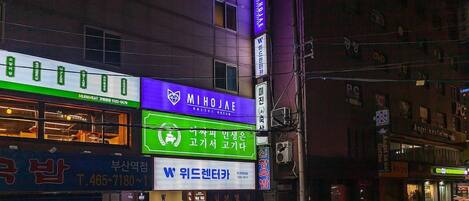 A building with multiple signs, including one for a hotel and another for a business.