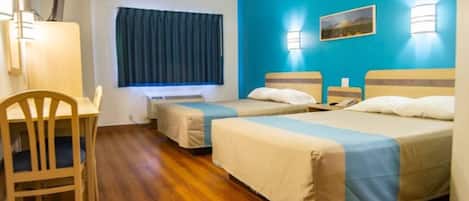 Habitación de hotel con dos camas, un escritorio, una silla, una ventana con cortinas e iluminación en la pared.