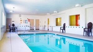 An indoor swimming pool with a clear water surface, surrounded by walls with doors and windows, and equipped with poolside chairs. - 2 Queen Beds | Non-Smoking (Las Cruces)