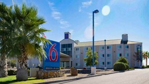A hotel with a large '6' sign, indicating it is the sixth property of a chain. It features a modern building with multiple windows and a flat roof. - 2 Queen Beds | Non-Smoking (Las Cruces)